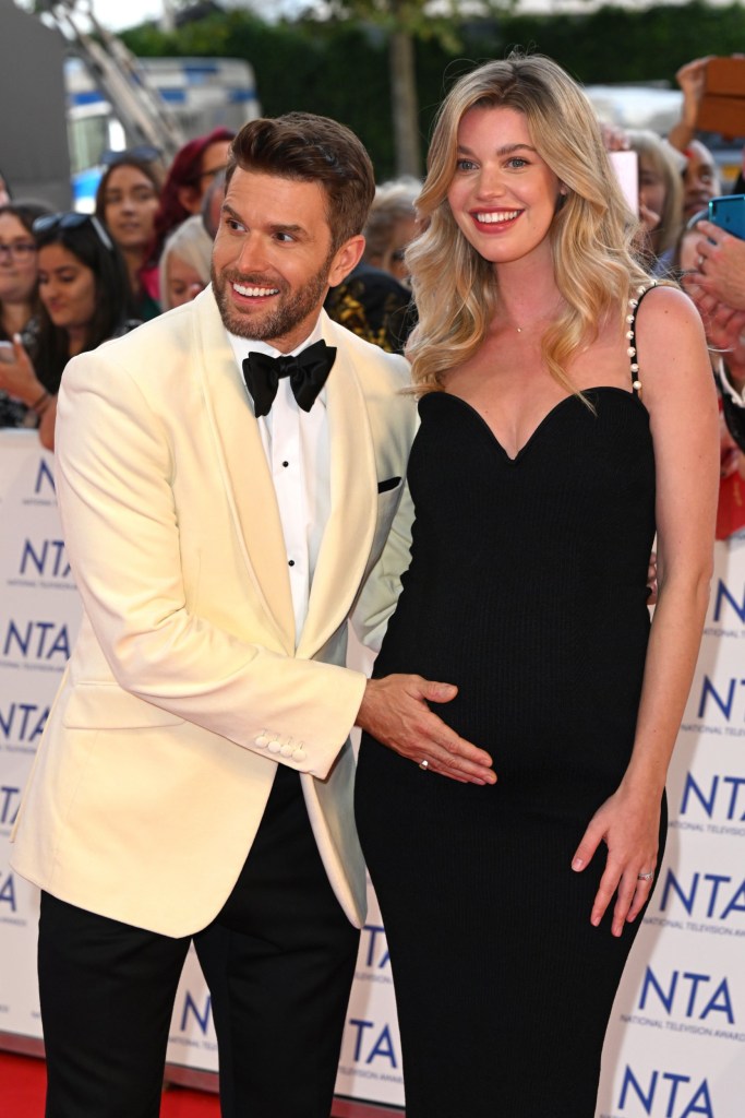 Joel Dommett craddles his wife Hannah Cooper's baby bump on the red carpet