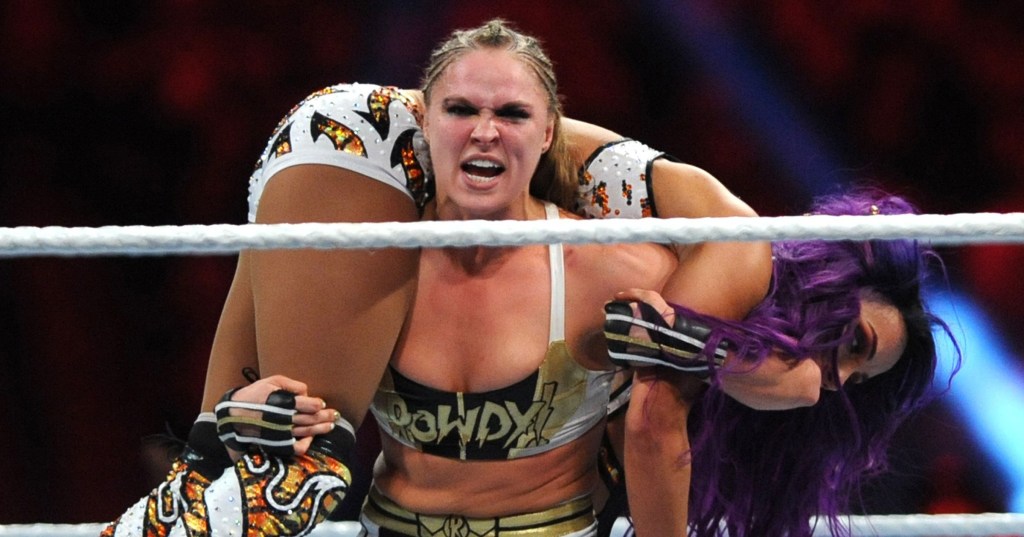Ronda Rousey lifting a wrestler over her shoulders on WWE