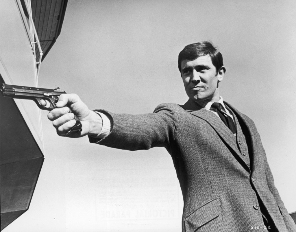 George Lazenby aiming a gun for the James Bond film, 'On Her Majesty's Secret Service,' directed by Peter Hunt, 1969 