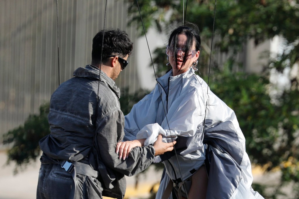 Katy Perry holding hands with a stuntman on the set of her new music video