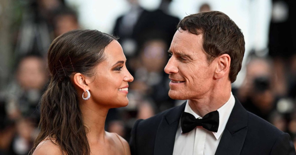 Swedish actress Alicia Vikander (L) and Irish actor Michael Fassbender looking at each other.
