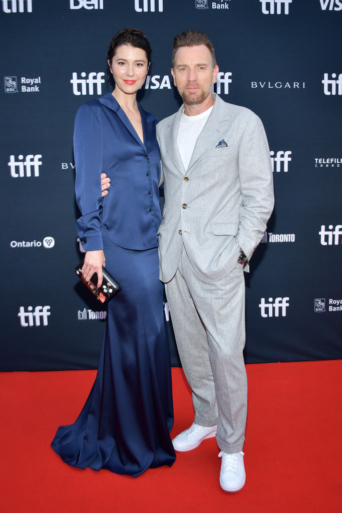 Mary Elizabeth Winstead and Ewan McGregor posing together at a red carpet event. Mary is wearing a blue gown while Ewan wears a grey suit