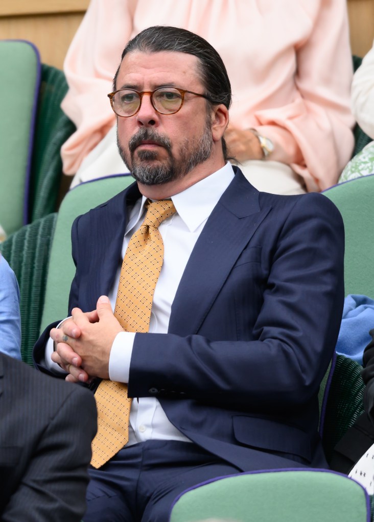 Dave Grohl wearing a suit and tie at Wimbledon