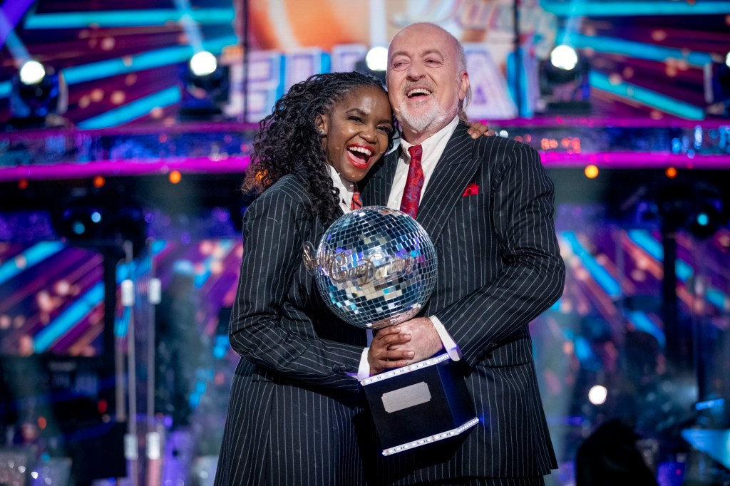 Bill Bailey and Oti Mabuse on Strictly Come Dancing lifting up the Glitterball Trophy 