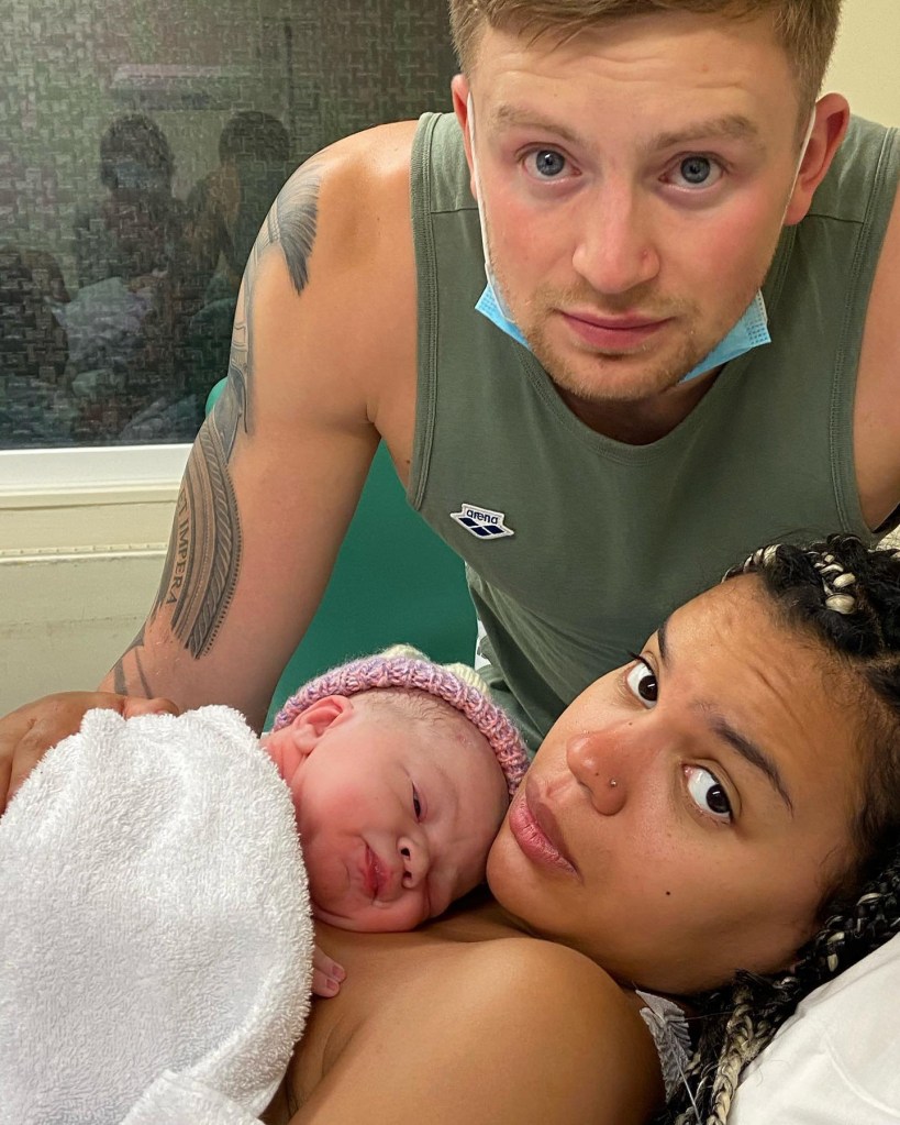 Eirianedd Munro holding her newborn son George with Adam Peaty standing next to them