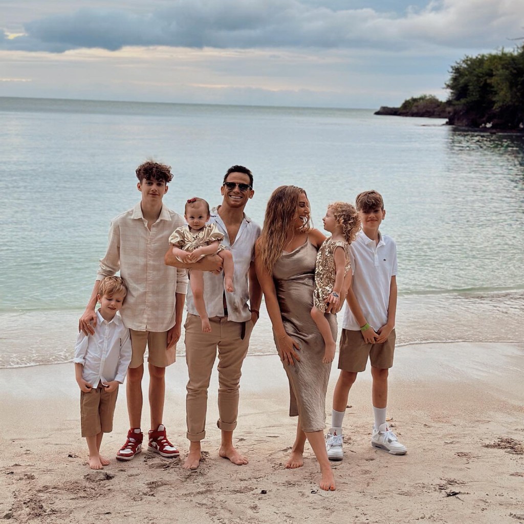 Stacey Solomon poses on the beach with her husband Joe Swash and five children, all dressed in neutral colours