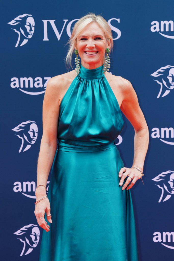 Jo Whiley on the red carpet in a turquoise dress, posing with her hand on her hip