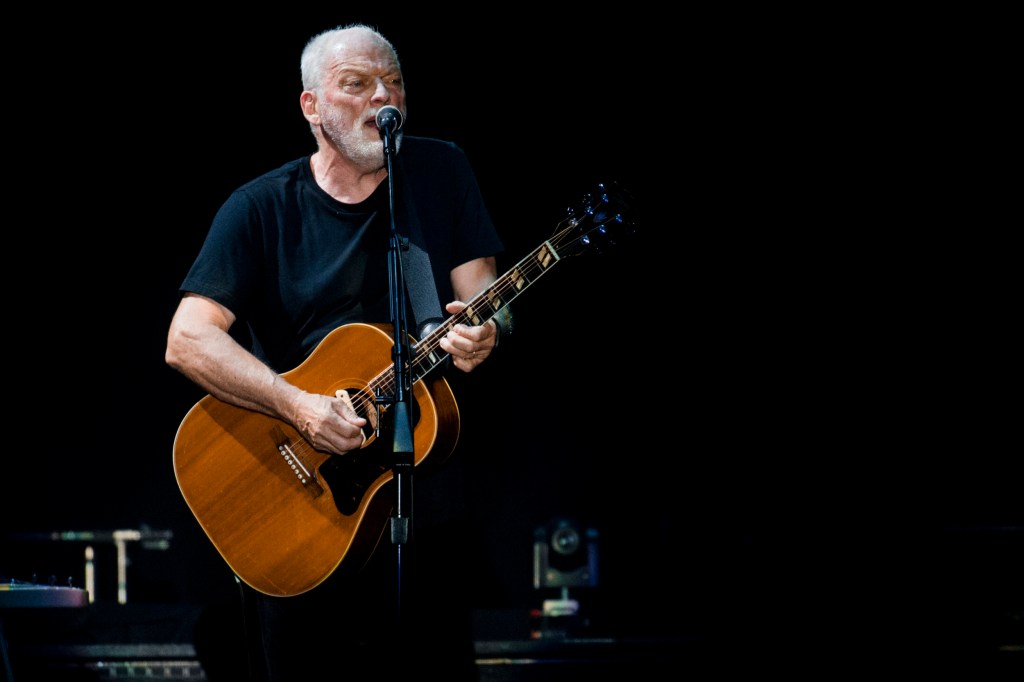 David Gilmour performs on stage with a guitar