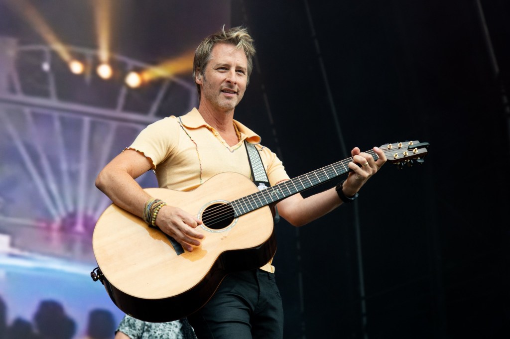 Chesney Hawkes performs on stage with a guitar