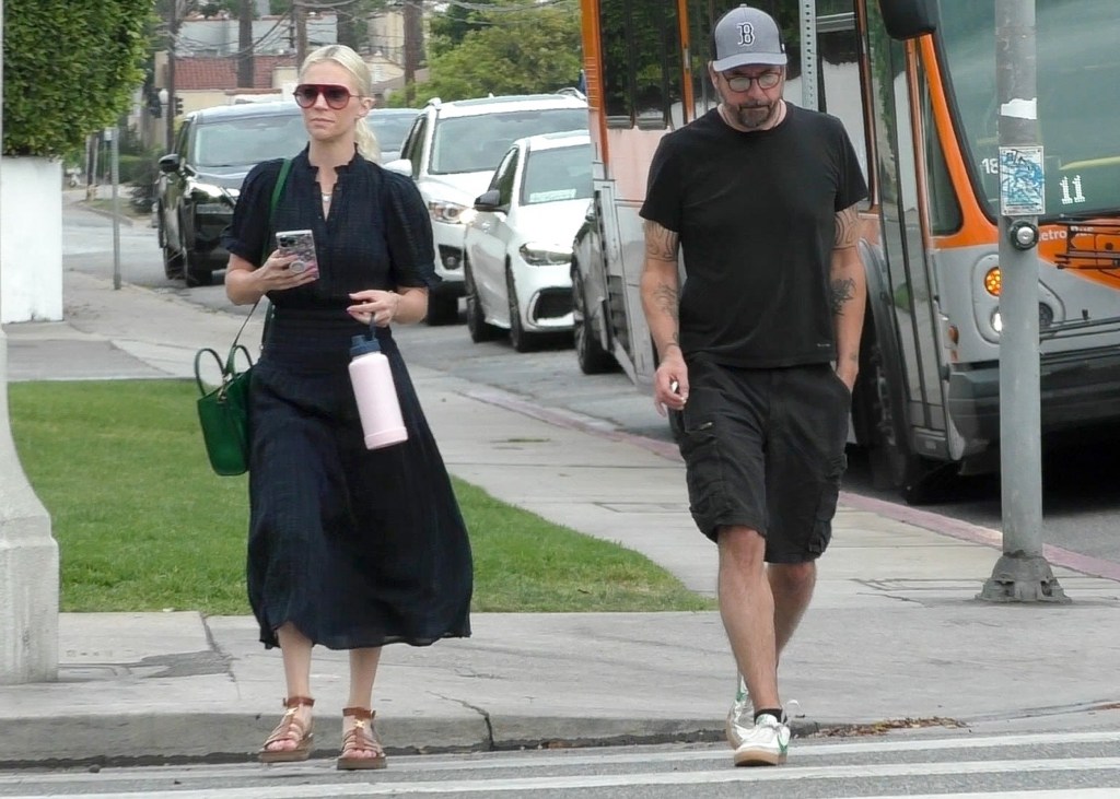 Jordyn Blum without her wedding ring holding her phone and Dave Grohl walking together