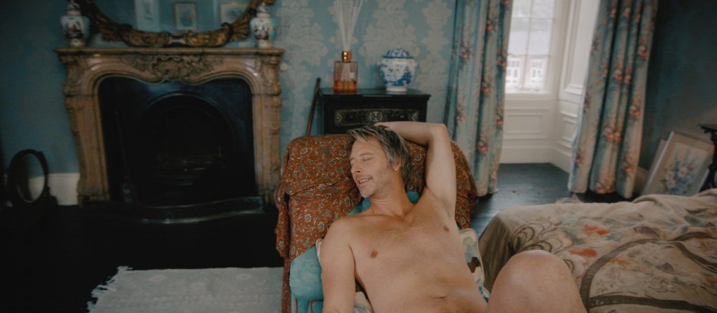 Chesney Hawkes poses naked in a chair in a mansion