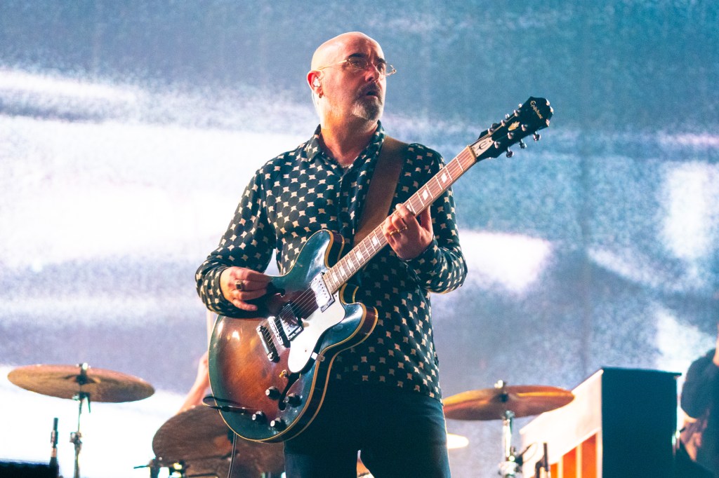 Paul 'Bonehead' Arthurs plays guitar on stage