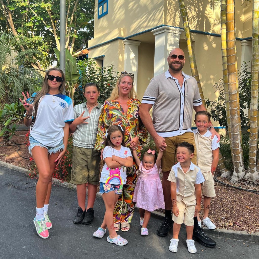 Tyson Fury, Paris Fury and six of their children pose outside of a villa with palm trees