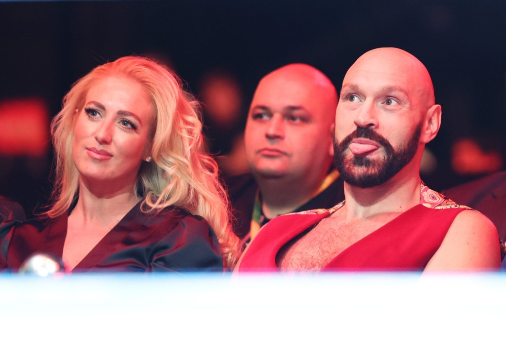 Tyson Fury sticks out his tongue, as he sits next to smiling wife Paris Fury