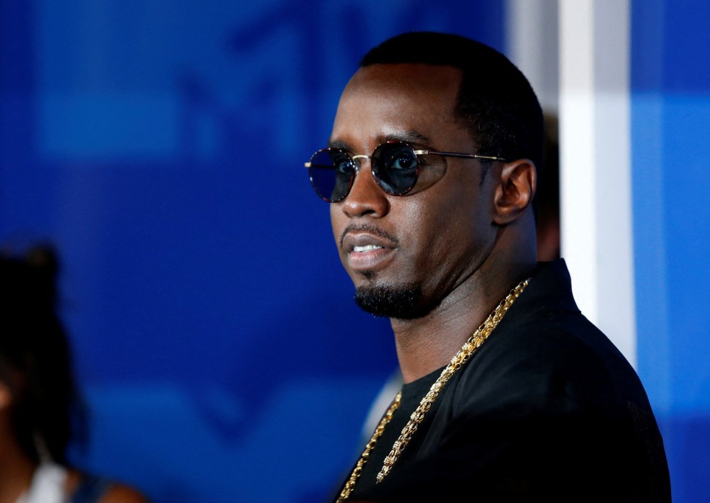 Rapper Sean Diddy Combs wears sunglasses and gold chain at carpet event