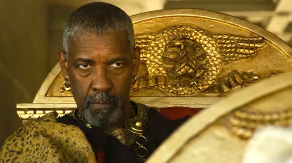 Denzel Washington as Marcinus sits in gold carraige with murderous look on his face in Gladiator 2