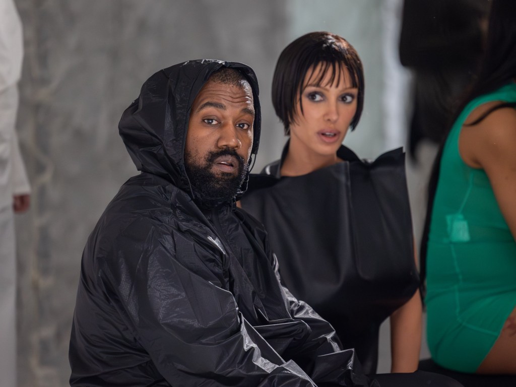 Kanye West and wife Bianca Censori at a fashion show in 2024, dressed in all black outfits