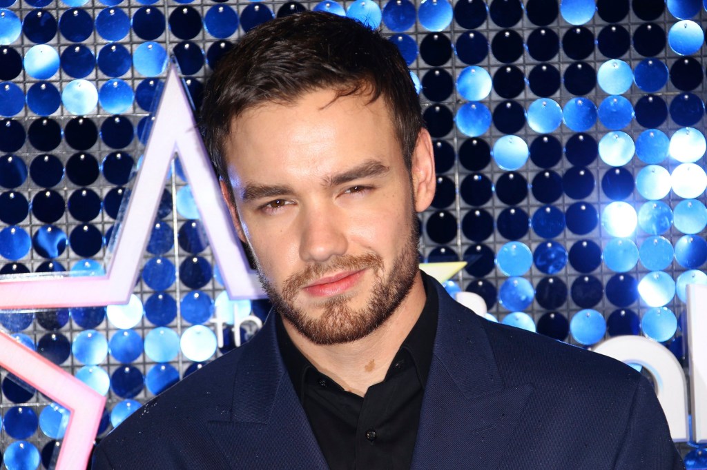 Liam Payne smiles to the camera, against a sequinned backdrop, in 2019.