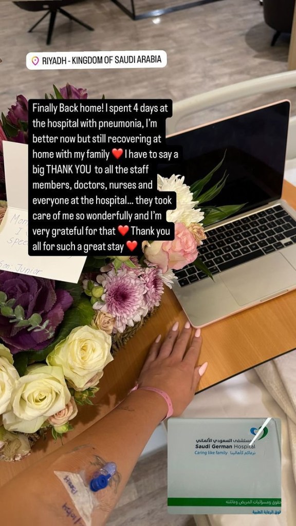 An Instagram post from Georgina Rodriguez showing her arm with hospital equipment, a bunch of flowers, a get well soon card, and a laptop