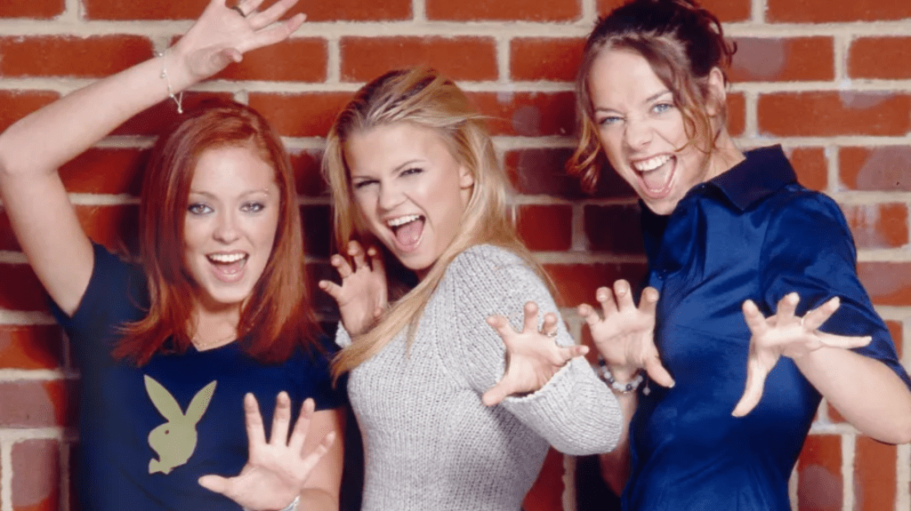 Natasha Hamilton, Kerry Katona and Liz McClarnon pose with their hands as claws, in a promo image for girl group Atomic Kitten